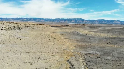 Aerial-Pull back-Distant mountain-Vast desert-various mesas Stock-Footage 148342577