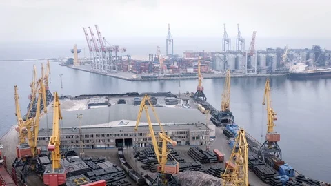 Aerial pull back from docks in Odessa Ukraine as ships are loaded up at sunrise Stock Footage 122528499
