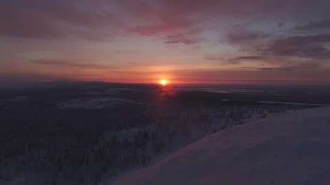 Aerial pull back drone shot of a stunning winter sunrise over Luosto, Lapland Stock Footage 340335557