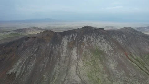 Aerial pull back from eroded volcanic mountain ridge near Nesjavellir, Iceland Stock Footage 346552202