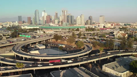 Aerial pull back of Los Angeles, CA downtown buildings and freeway loop Stock Footage
