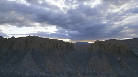 Aerial-Pull back Mesa Butte view through gap in cliff face to setting sun Stock Footage 241676310