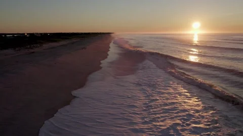 Aerial Pull Back of Ocean Waves Crushing on Beach at Sunrise Stock Footage 328333621