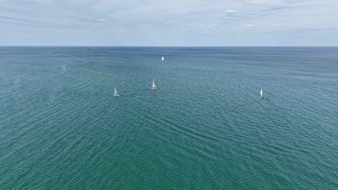 Aerial Pull-Back Over Colorful Catamarans Sailing on Open Blue Lake Water 库存影片 336872648