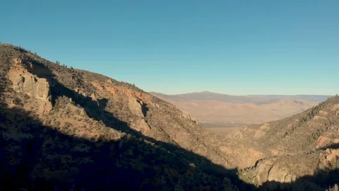 Aerial-Pull back over rock formation from view of distant valley Stock Footage 98606169