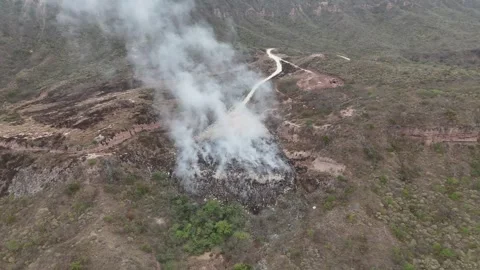 Aerial pull back reveal of burning garbage dump and toxic smoke Stock Footage 340921513