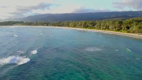 Aerial pull back reveal of surfers at sunrise Stock Footage 78075756