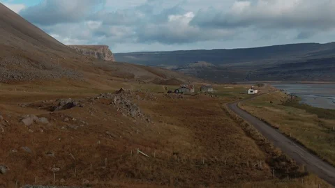 Aerial pull back revealing view of a black church in a fjord in West Iceland Stock Footage 116861613