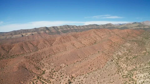 Aerial pull back shot of colorful red, orange, white desert landscape, greenery Stock Footage 123443000