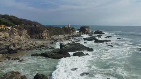 Aerial pull-back shot over Zicatela beach starting at the lighthouse. Stock Footage 333708607
