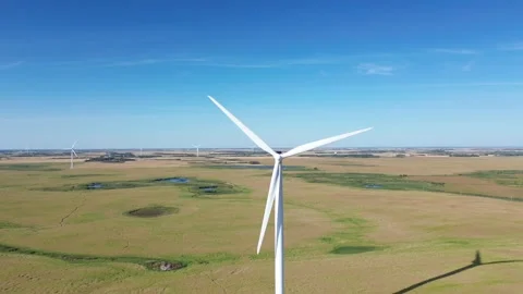 Aerial pull-back shot revealing a large wind turbine in a vast landscape. Stock Footage 316638414