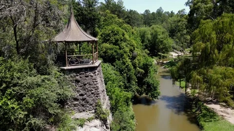 Aerial pull-back shot of a rustic riverside gazebo Video stock 338414523