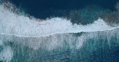 Aerial pull back showing waves breaking with swirling undertow underneath Vídeo Stock 87573460