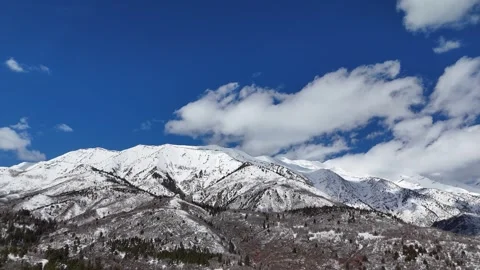 Aerial-Pull back- Snowy mountain scene-Clouds move slowly by Stock Footage 268491799