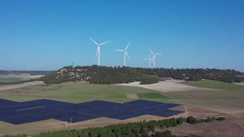 Aerial Pull Back from Solar Farm with Wind Turbines Renewable Energy Concept Stock Footage 329711104