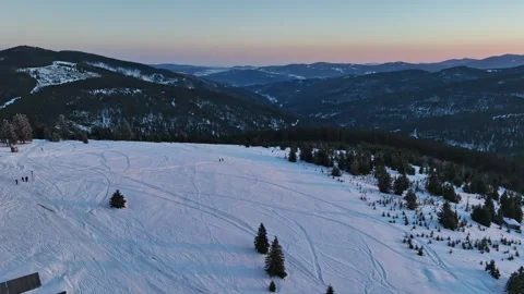 Aerial pull back tracking hikers silhouettes walking on winter slope Stock Footage 336445964
