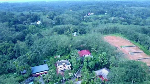 Aerial pull-back from tropical homes to a large, marked land plot for new Stock Footage 321357297