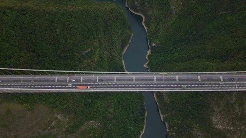 Aerial Pull Back Vast Canyon Suspension Bridge Traffic 4K HLG Stock Footage 345620529