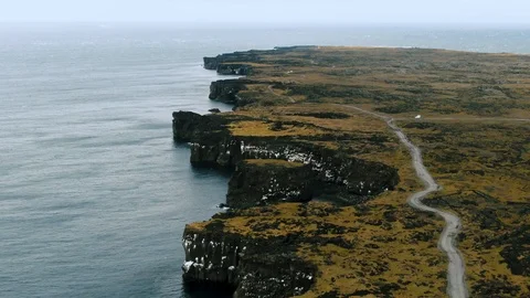 Aerial pull back view of a coast in West Iceland revealing a lighthouse Stock Footage 116861658