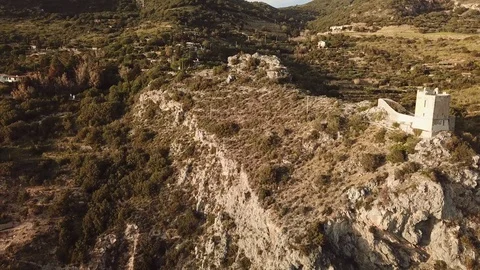 Aerial pull back view of a medieval tower on a high cliff at sunset Stock Footage 104490068