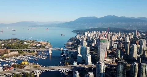 Aerial pull back from West End Vancouver with bridges and mountains Vídeo Stock 93426541