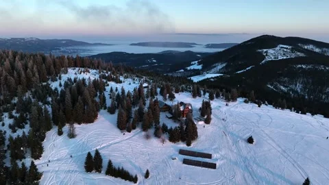 Aerial pull back from wooden mountain shelter chalet at sunrise Stock Footage 336446092