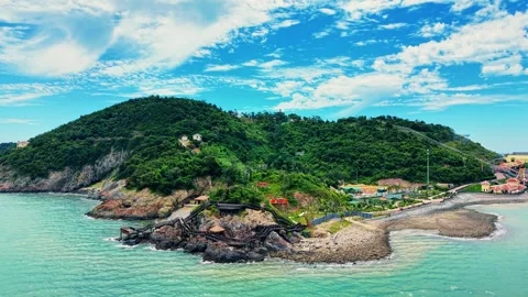 Aerial pull back from wooden ocean walkways revealing Song Ngu Island 4K Stock Footage 340303925