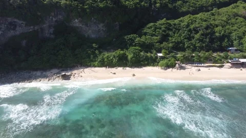 Aerial pull out from cliffs to ocean, Nyang Nyang Beach Bali Stock Footage 328993977