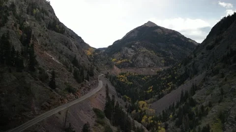 Aerial pull out from Million Dollar Highway near Ouray Colorado on cloudy day Stock Footage 287650811