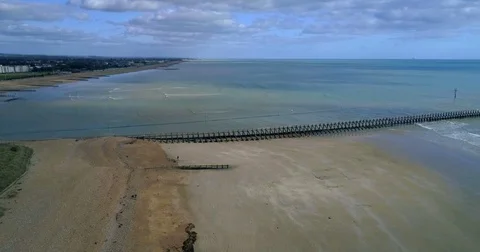Aerial pull out view of a beach and the mouth of a river in Southern England Stock Footage 81735601