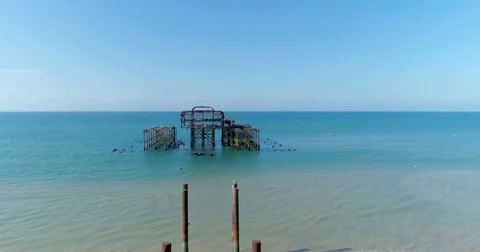 Aerial pull out view of the destroyed West Pier in Brighton on a summer morning Stock Footage 77748287