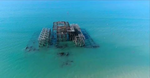 Aerial pull out view of the destroyed West Pier in Brighton on a summer morning Stock Footage 78244896