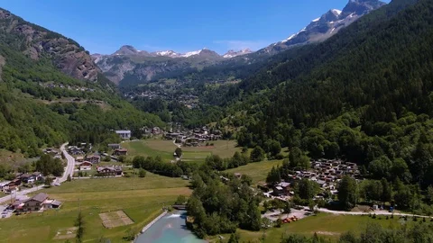 Aerial pull out view of mountain villages by a lake in the Italian Alps Stock Footage 113674925
