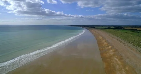 Aerial pull out view of a sandy beach next to a golf course in Southern England Stock Footage 81192650