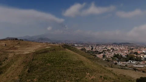 Aerial pull out view of a small crater with Mount Etna in Sicily Stock Footage 106398636