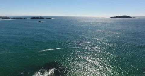 Aerial Pull Shot of waves breaking on rocks Stock Footage 106848646