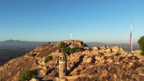 Aerial Pullaway Reveals Mt Rubidoux Cross, Tower, and Flag on Rocky Hilltop at Stock Footage 345695414