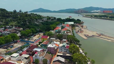 Aerial pullback above Coloane Village coastline with ferry boat Stock Footage 340200576
