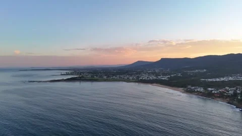 Aerial pullback along Thirroul's coastline at sunset, highlighting the Vídeos de archivo 285376110