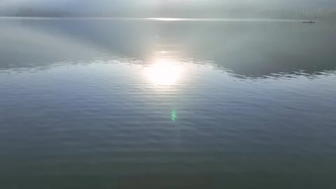 Aerial pullback and tilt-up revealing a Dal Lake sunrise and mountain hill Видео 333792977