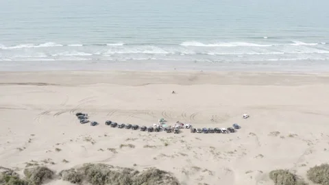 Aerial pullback from a beach vehicle gathering at Sidi Rahal Video stock 347848152