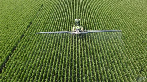 Aerial Pullback from Boom Sprayer Applying Crop Treatment to Corn Rows Video stock 346714481