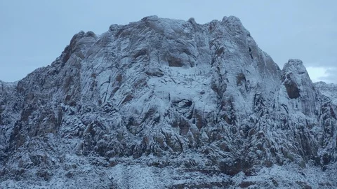 Aerial pullback dawn shot of snow covered desert mountains at Red Rock Canyon Stock Footage 122052090