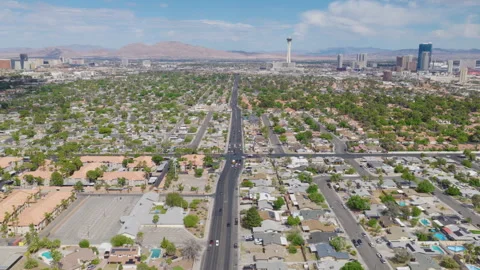 Aerial pullback drone shot of Las Vegas homes and Strip downtown city skyline Stock Footage 333484450