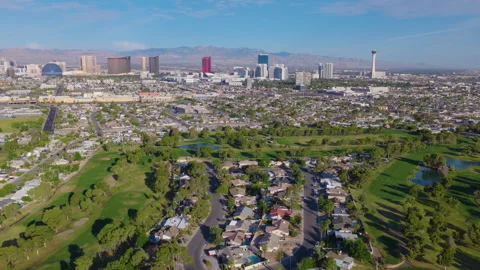 Aerial pullback drone shot of Las Vegas suburbs and city skyline and streets Stock Footage 333487658