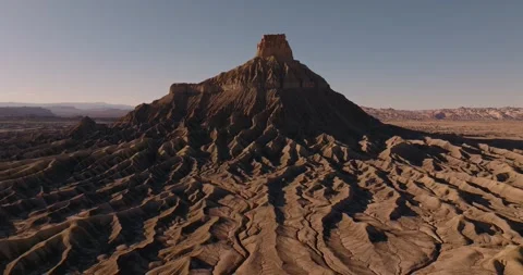 Aerial Pullback of Factory Butte Above Rugged Utah Desert Ridges Video stock 333414978