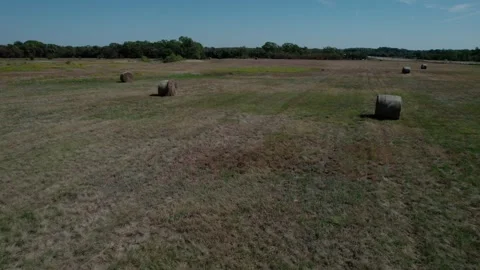Aerial pullback of hay rolls in a rural farm field Stock Footage 318729133
