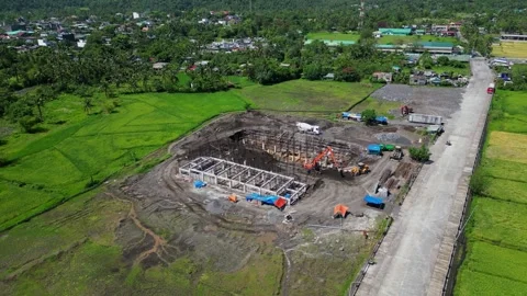 Aerial pullback of Malilipot construction area with green hills and beams Vídeos de archivo 308695224