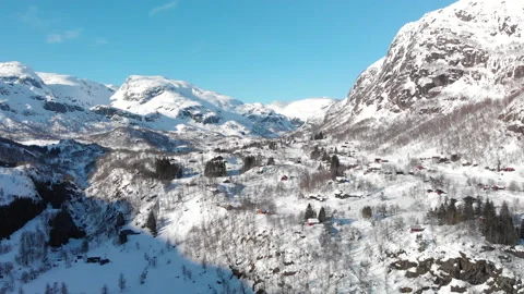 Aerial pullback of mountain valley covered in snow with cabins Stock Footage 145831381