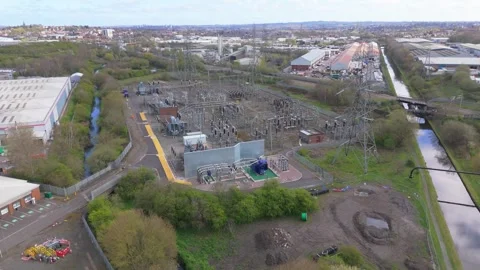 An aerial pullback movement of a high voltage electricity substation Stock Footage 332510642